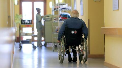 Ein Rentner fährt mit seinem Rollstuhl über einen Flur in einem Seniorenheim. Der Kommissar ermittelt in einem solchen.