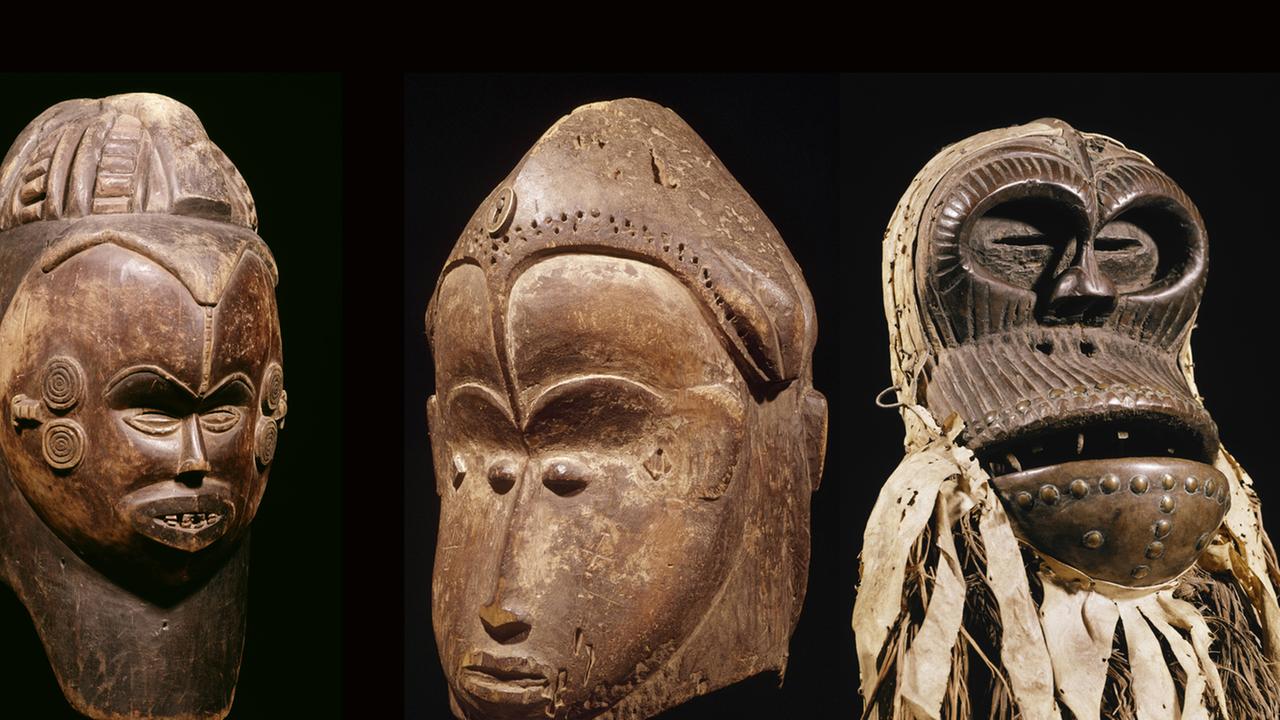 Von links nach rechts: doppelgesichtige Helmmaske aus Nigeria, doppelgesichtige Maske aus Gabun und eine hölzerne Schimpansenmaske von der Elfenbeinküste.