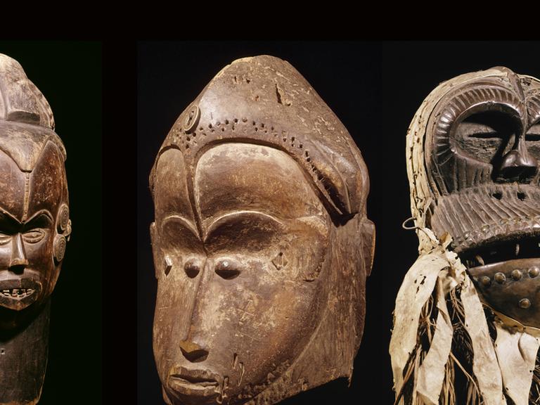 Von links nach rechts: doppelgesichtige Helmmaske aus Nigeria, doppelgesichtige Maske aus Gabun und eine hölzerne Schimpansenmaske von der Elfenbeinküste.