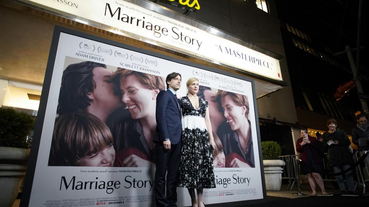 Regisseur Noah Baumbach und seine Frau Greta Gerwig stehen auf einem dunklen Teppich. Hinter Ihnen ist das übergroße Filmplakat von "Marriage Story" zu sehen. Regisseur Noah Baumbach und seine Frau Greta Gerwig stehen auf einem dunklen Teppich. Hinter Ihnen ist das übergroße Filmplakat von "Marriage Story" zu sehen.