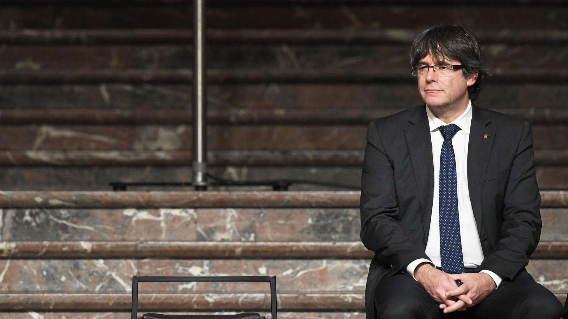 Carles Puigdemont sitzt auf der Stufe einer breiten Treppe eines Gebäudes in Brüssel Carles Puigdemont sitzt auf der Stufe einer breiten Treppe eines Gebäudes in Brüssel