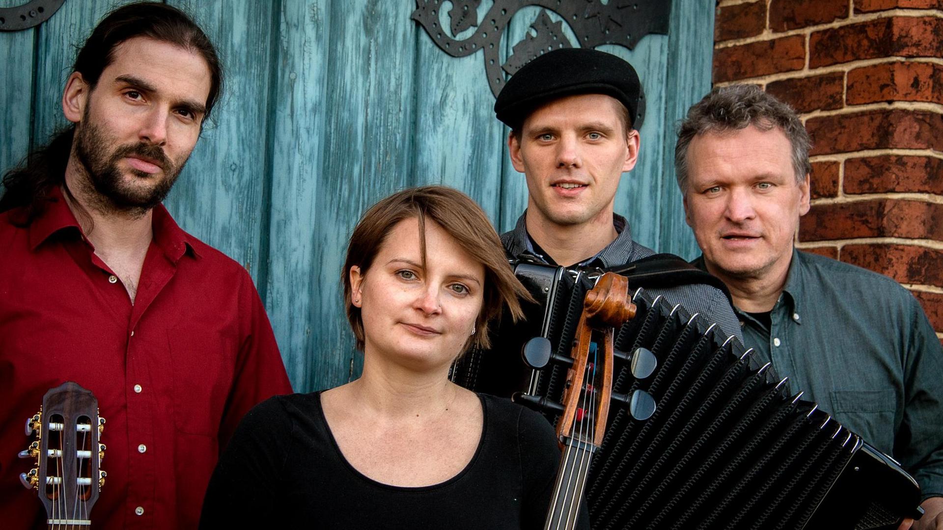 Die vier Musiker der Band Die Grenzgänger stehen mit ihren Instrumenten beisammen Die vier Musiker der Band Die Grenzgänger stehen mit ihren Instrumenten beisammen