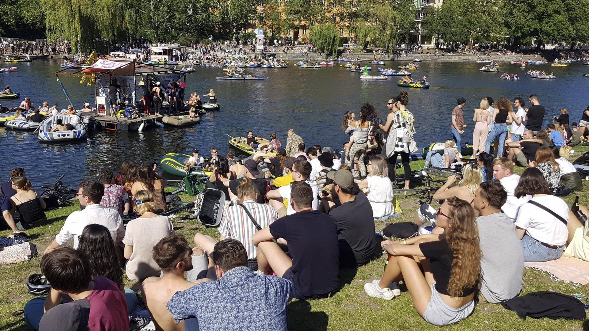 Eine große Menge junger Leute Pfingsten 2020 am Ufer des Berliner Landwehrkanals. Sie sitzen dicht an dicht auf dem Rasen und demonstrieren für Partykultur und Ravekultur. Eine große Menge junger Leute Pfingsten 2020 am Ufer des Berliner Landwehrkanals. Sie sitzen dicht an dicht auf dem Rasen und demonstrieren für Partykultur und Ravekultur.