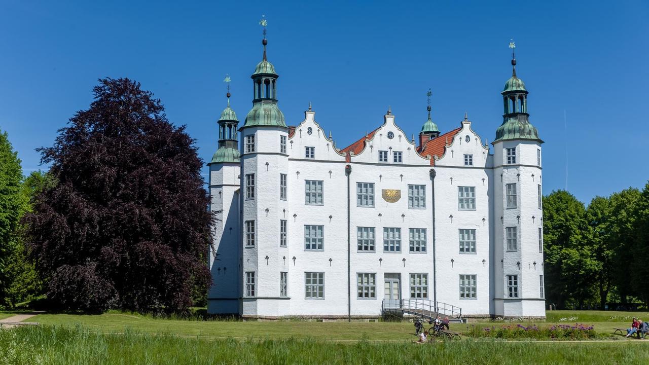 Ein weißes Schloss mit Türmchen leuchtet unter blauem Himmel. Ein weißes Schloss mit Türmchen leuchtet unter blauem Himmel.