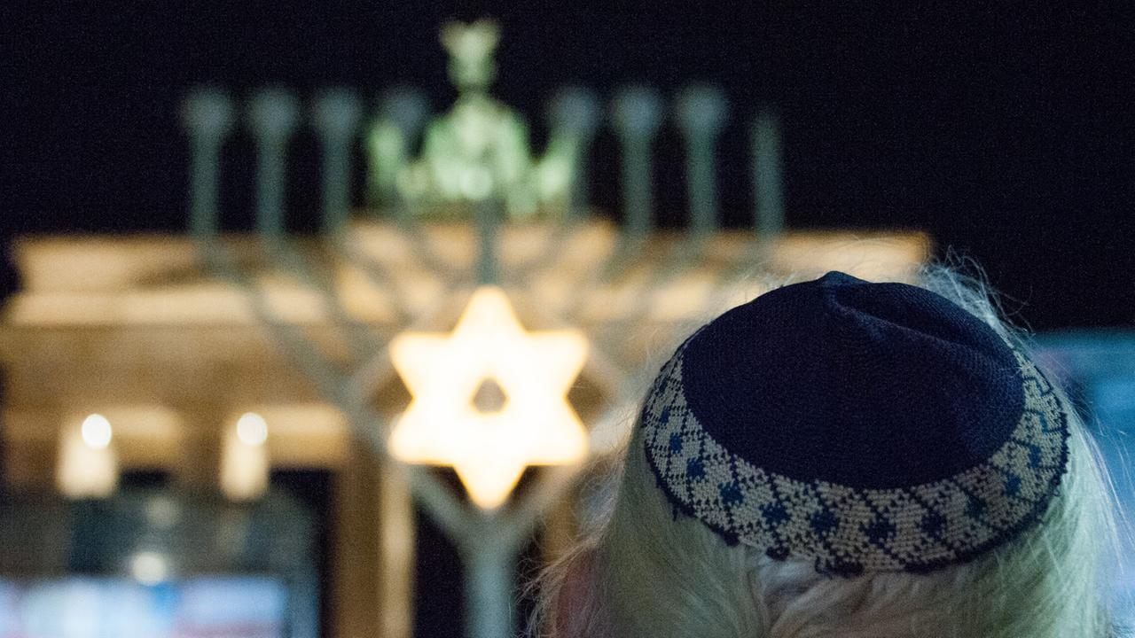 Ein Mann mit Kippa steht am 16. Dezember 2014 in Berlin vor dem Brandenburger Tor. Hier wurde am Abend der Chanukka-Leuchter entzündet. Ein Mann mit Kippa steht am 16. Dezember 2014 in Berlin vor dem Brandenburger Tor. Hier wurde am Abend der Chanukka-Leuchter entzündet.
