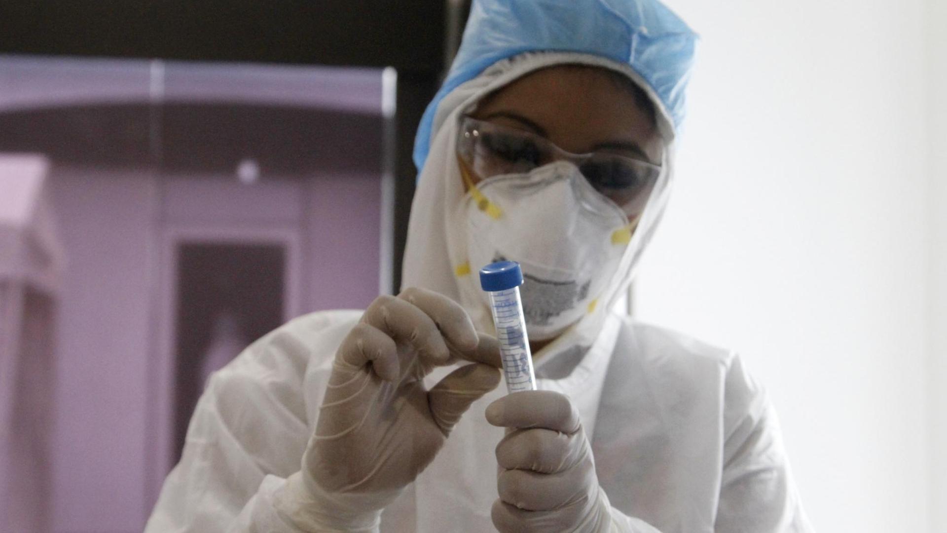 Biologin mit Schutzkleidung bei einem COVID-19-Test im Labor Biologin mit Schutzkleidung bei einem COVID-19-Test im Labor
