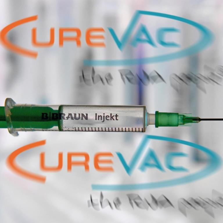 Das Foto zeigt eine Spritze vor dem Logo des Unternehmens CureVac.