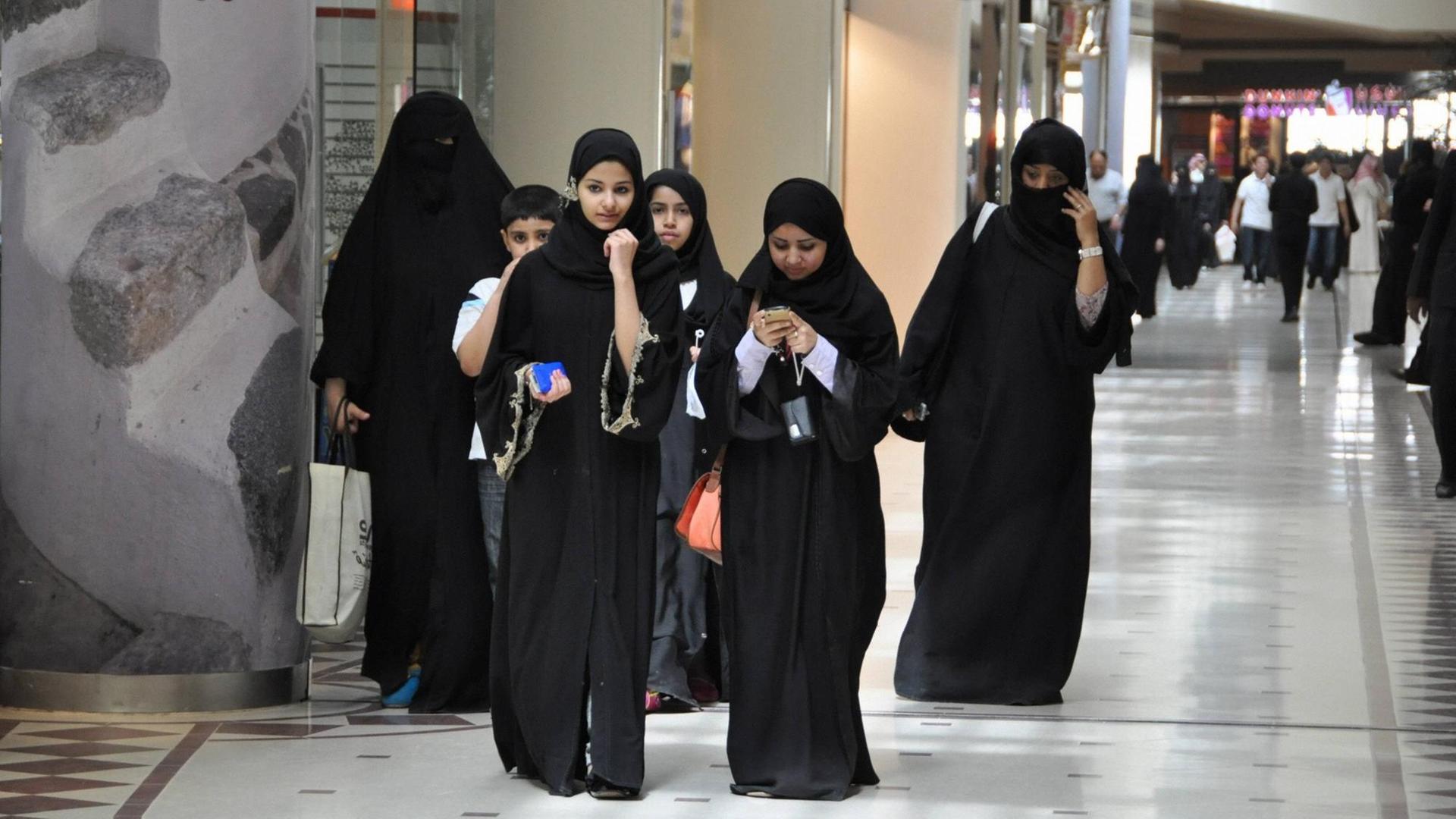 Eine Gruppe von jungen Frauen, gekleidet in den traditionellen schwarzen Umhang, die Abaya, geht durch eine Shopping Mall in der saudi-arabischen Hauptstadt Riad. Eine Gruppe von jungen Frauen, gekleidet in den traditionellen schwarzen Umhang, die Abaya, geht durch eine Shopping Mall in der saudi-arabischen Hauptstadt Riad.
