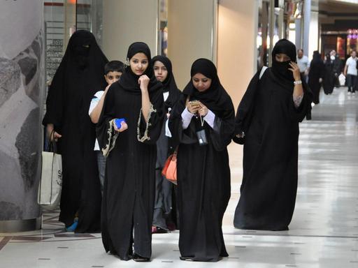 Eine Gruppe von jungen Frauen, gekleidet in den traditionellen schwarzen Umhang, die Abaya, geht durch eine Shopping Mall in der saudi-arabischen Hauptstadt Riad.