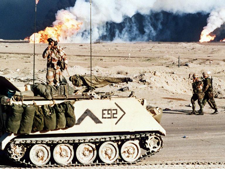 Golfkrieg von 1991 - US-Streitkräfte: Ein amerikanischer Schützenpanzer vor brennenden Ölfeldern nahe der kuwaitisch-irakischen Grenze am 2.3.1991. Die Golfkrise hatte am 2.8.1990 mit dem Einmarsch irakischer Truppen nach Kuwait begonnen. Der UN-Sicherheitsrat forderte daraufhin am 29.11.1990 den Irak auf, seine Truppen bis zum 15.1.1991 aus Kuwait zurückzuziehen. Nach Ablauf des UN-Ultimatums begannen am 17.1.1991 alliierte Streitkräfte unter der Führung der USA mit der Bombardierung Bagdads. Der Golfkrieg endete nach dem Einlenken Iraks am 28.2. 1991 mit der Einstellung aller Kampfhandlungen. Am 20..3.2003 haben amerikanische und britische Truppen einen neuen Krieg gegen den Irak begonnen.