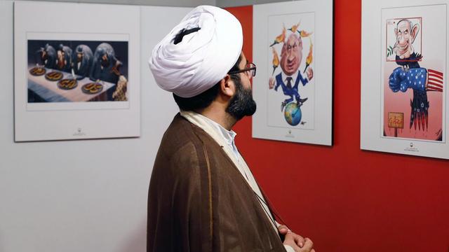Besucher betrachtet Karikatur im Rahmen der zweiten Holocaust-Ausstellung in Teheran.