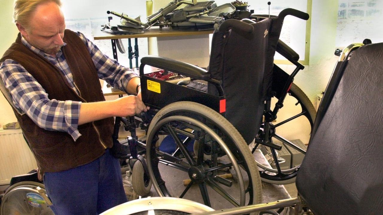 Ein Mitarbeiter der Werkstatt für gebrauchte medizintechnische Geräte des Vereins Start e.V. in Schwerin repariert am einen Rollstuhl. Ein Mitarbeiter der Werkstatt für gebrauchte medizintechnische Geräte des Vereins Start e.V. in Schwerin repariert am einen Rollstuhl.