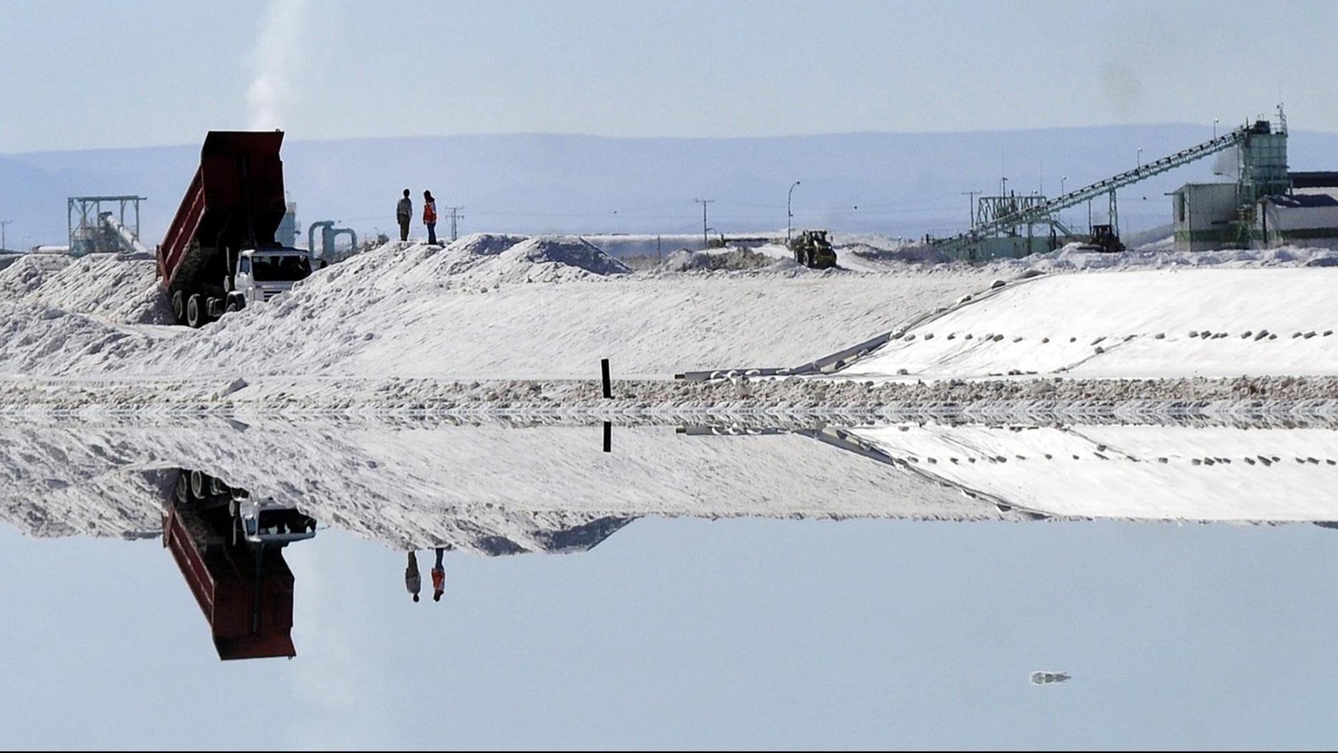 Arbeiter stehen am Verdunstungsbecken der SQM im Salzsee in der Atacamawüste im Norden Chiles Arbeiter stehen am Verdunstungsbecken der SQM im Salzsee in der Atacamawüste im Norden Chiles