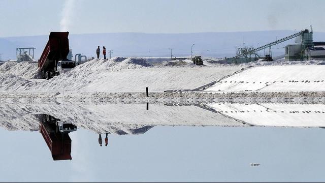 Arbeiter stehen am Verdunstungsbecken der SQM im Salzsee in der Atacamawüste im Norden Chiles