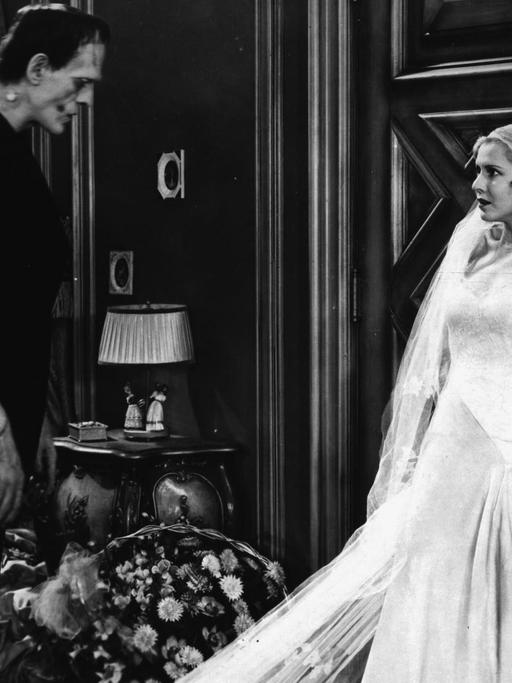 "Frankenstein" von 1931. Szene mit Schauspieler Boris Karloff. Frankenstein und eine Braut stehen in einem Zimmer.