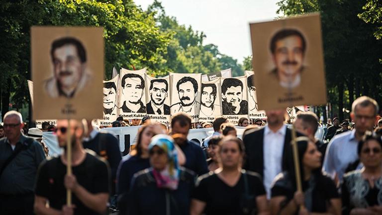 Das Foto zeigt die Teilnehmer einer Demonstration nach dem Urteil im NSU-Prozess. Sie halten Bilder der vom NSU Ermordeten hoch. Das Foto zeigt die Teilnehmer einer Demonstration nach dem Urteil im NSU-Prozess. Sie halten Bilder der vom NSU Ermordeten hoch.