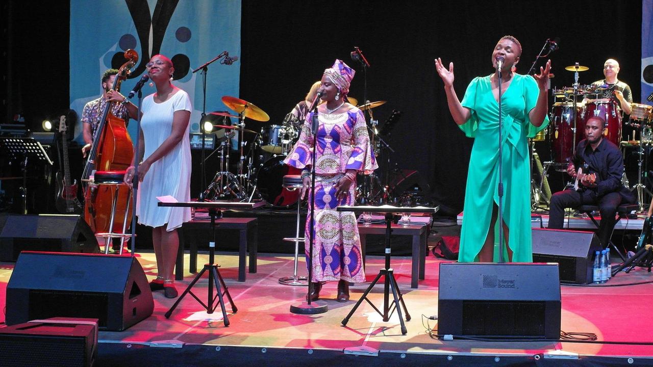 Die Sängerinnen Angelique Kidjo, Cécile McLorin Salvant und Lizz Wright stehen gemeinsam in Rudolfstadt auf der Bühne, hinter ihnen sind noch weitere Musiker.