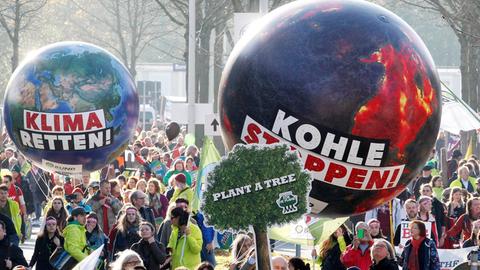 Demonstranten fordern in Bonn (Nordrhein-Westfalen) mit einem Modell der Erdkugel mit der Aufschrift "Klima retten" und einer weiteren mit der Aufschrift "Kohle stoppen" die Umsetzung des Weltklimaabkommens.