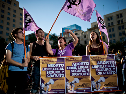 Frauen und Männer halten vor dem La Moneda Presidential Palace in Santiago Plakate hoch. Sie demonstrieren für ein freie, legale, sichere und selbstbestimmte Abtreibung in Chile.