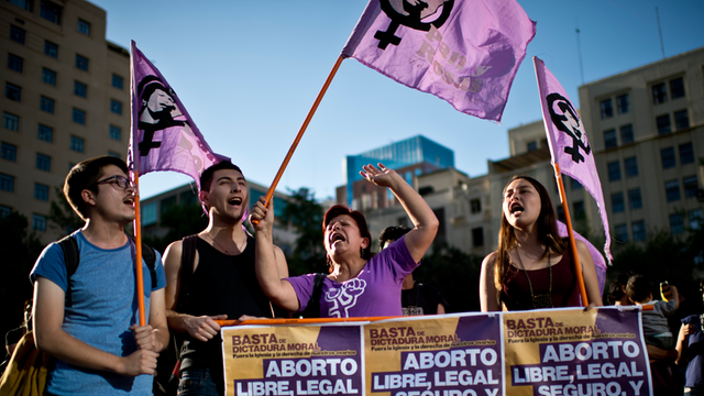 Frauen und Männer halten vor dem La Moneda Presidential Palace in Santiago Plakate hoch. Sie demonstrieren für ein freie, legale, sichere und selbstbestimmte Abtreibung in Chile.