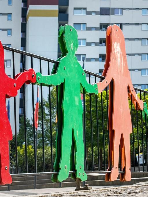 Bunte Silhouetten von Kinderfiguren an einem Kinderspielplatz.