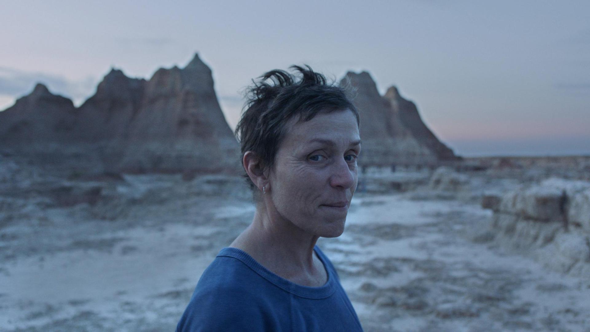 Die Schauspielerin Frances McDormand steht vor einer Felsen-Landschaft und lächelt. Die Schauspielerin Frances McDormand steht vor einer Felsen-Landschaft und lächelt.