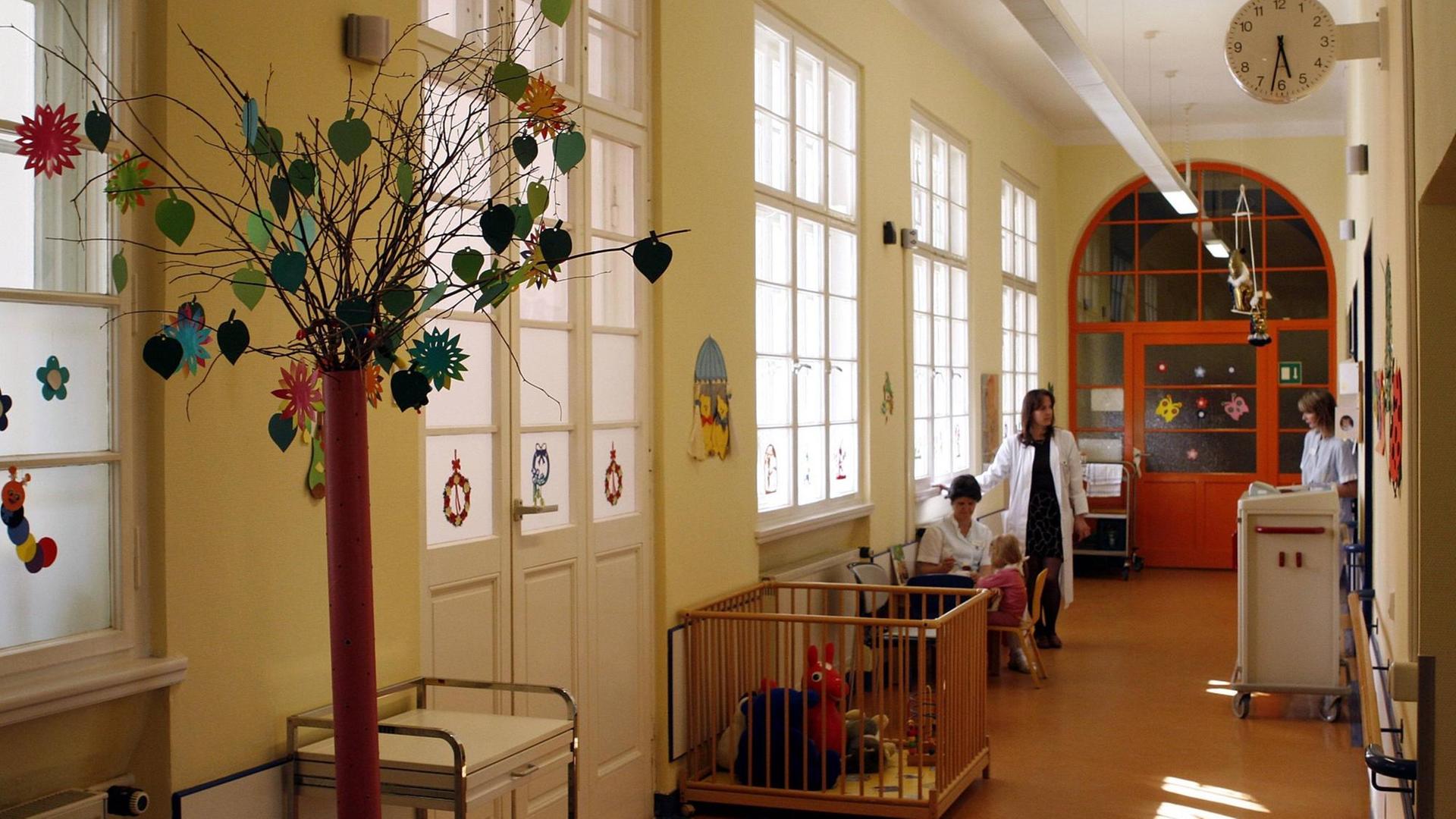 Ärzte, Mütter und Kinder in einem Gang einer Kinderklinik
