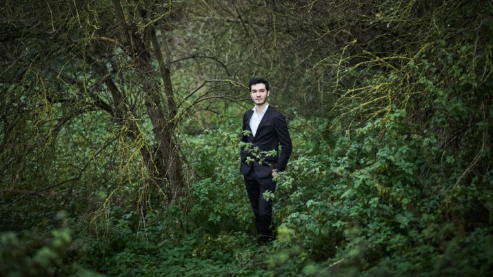 Der Musiker steht in einem wild gewachsenen Wald Der Musiker steht in einem wild gewachsenen Wald