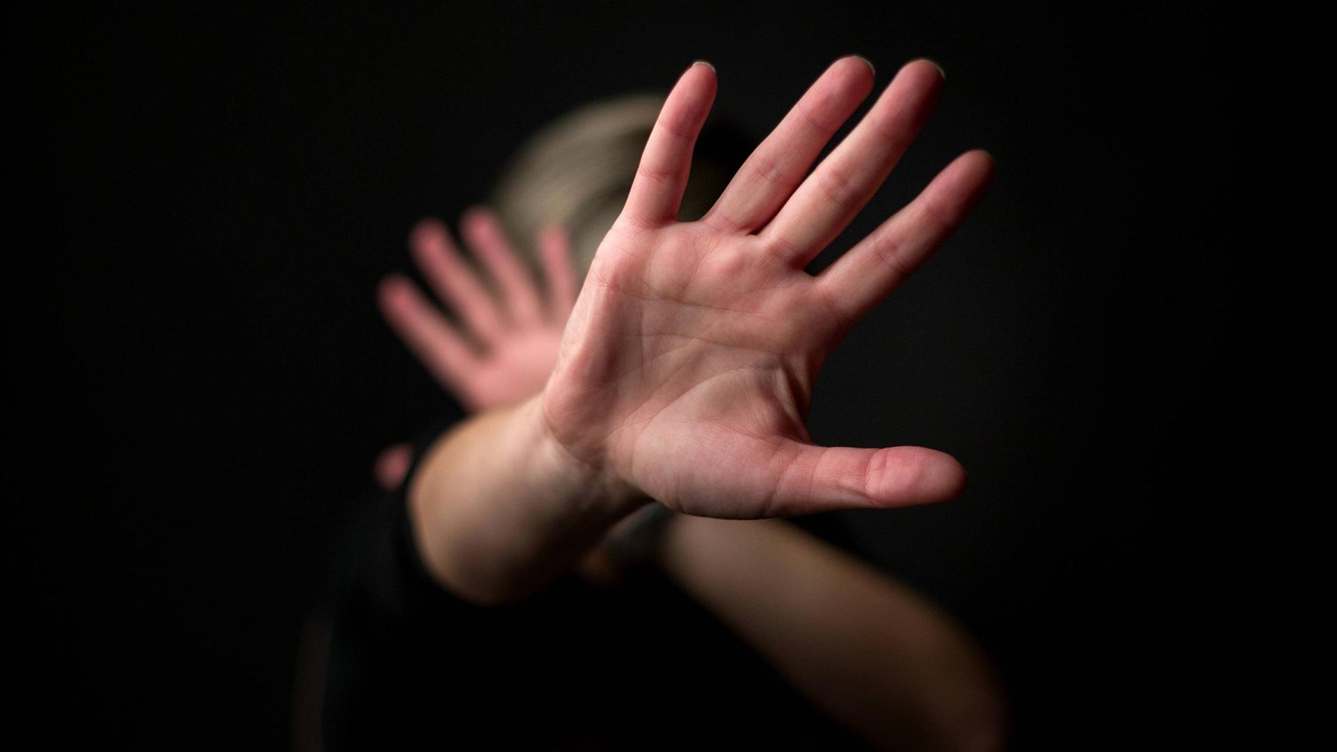 Eine Frau hält sich die Hände vor das Gesicht. Eine Frau hält sich die Hände vor das Gesicht.