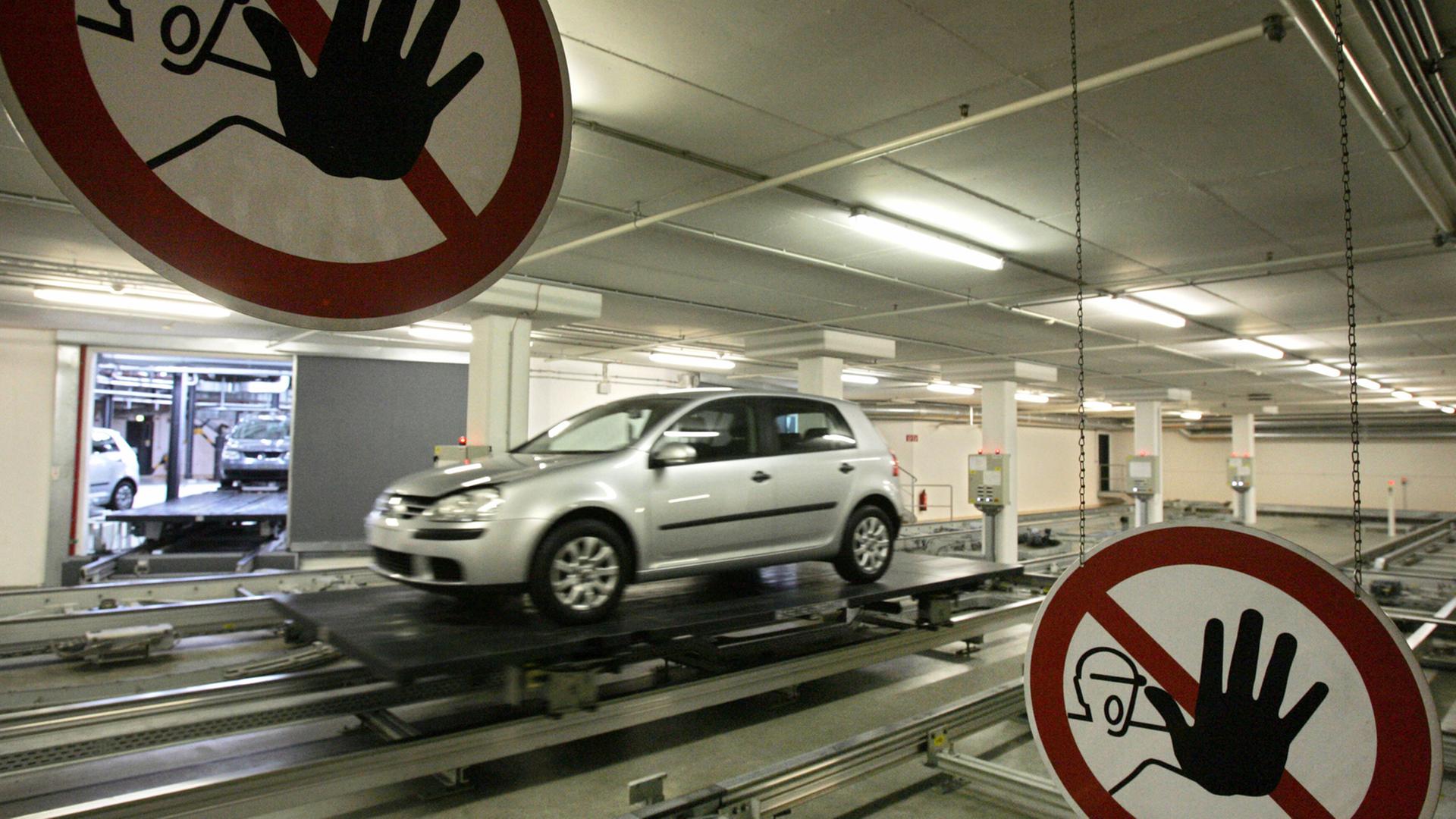 Ein von Robotern geführtes Auto im Volkswagen-Werk in Wolfsburg. Davor ein Warnschild, dort nicht händisch einzugreifen. Ein von Robotern geführtes Auto im Volkswagen-Werk in Wolfsburg. Davor ein Warnschild, dort nicht händisch einzugreifen.