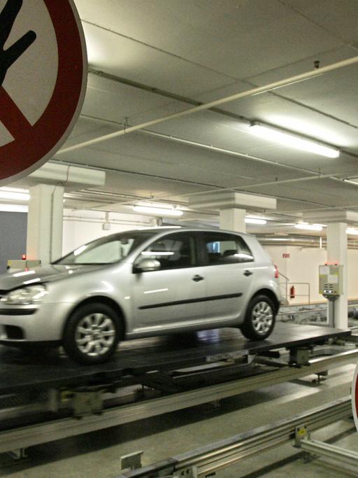 Ein von Robotern geführtes Auto im Volkswagen-Werk in Wolfsburg. Davor ein Warnschild, dort nicht händisch einzugreifen.