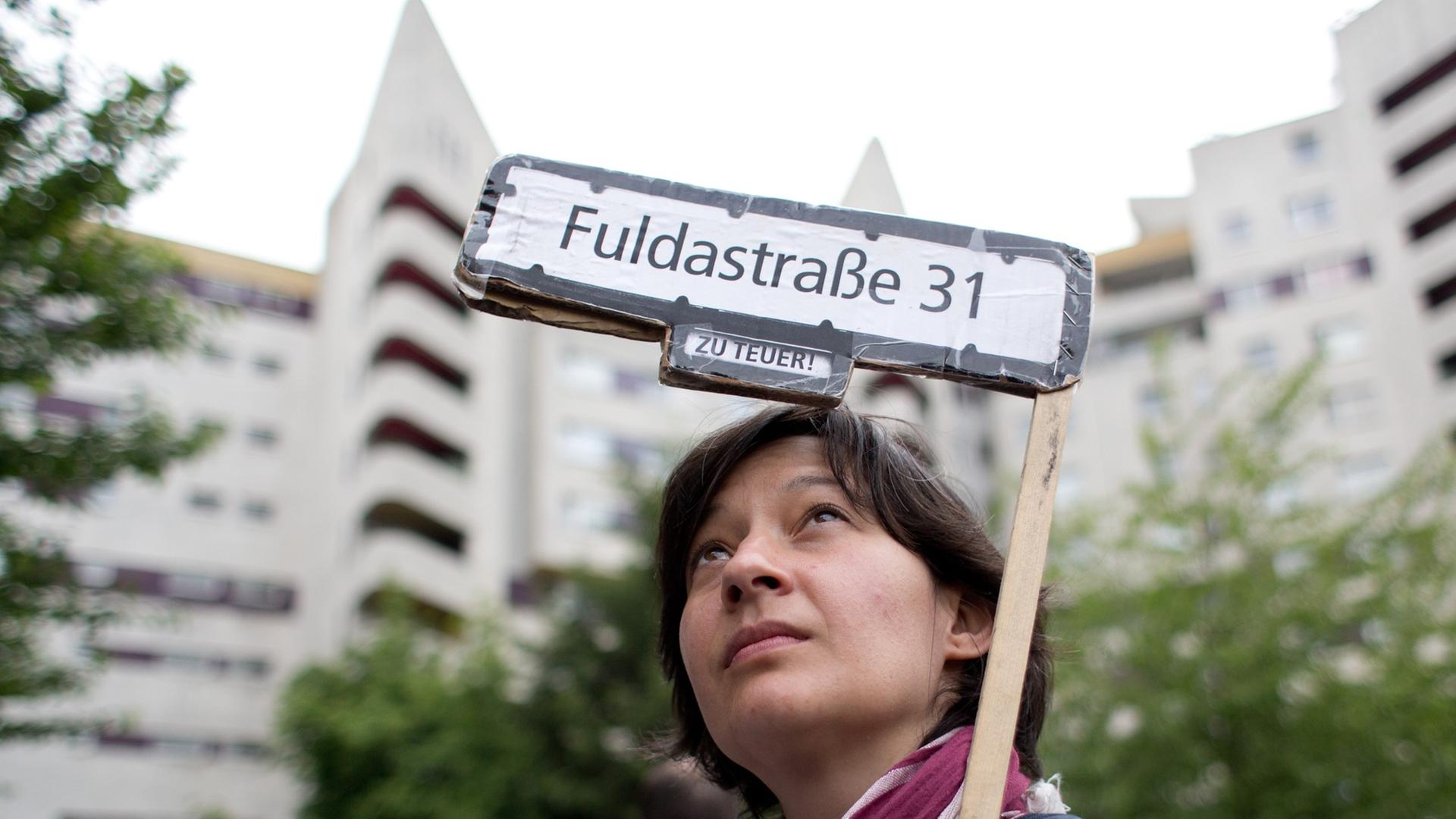 Eine Aktivistin hält ein Transparent hoch mit der Aufschrift "Fuldastraße 31 - zu teuer!" bei einer Demonstration gegen hohe Mieten und Verdrängung in Berlin. Eine Aktivistin hält ein Transparent hoch mit der Aufschrift "Fuldastraße 31 - zu teuer!" bei einer Demonstration gegen hohe Mieten und Verdrängung in Berlin.