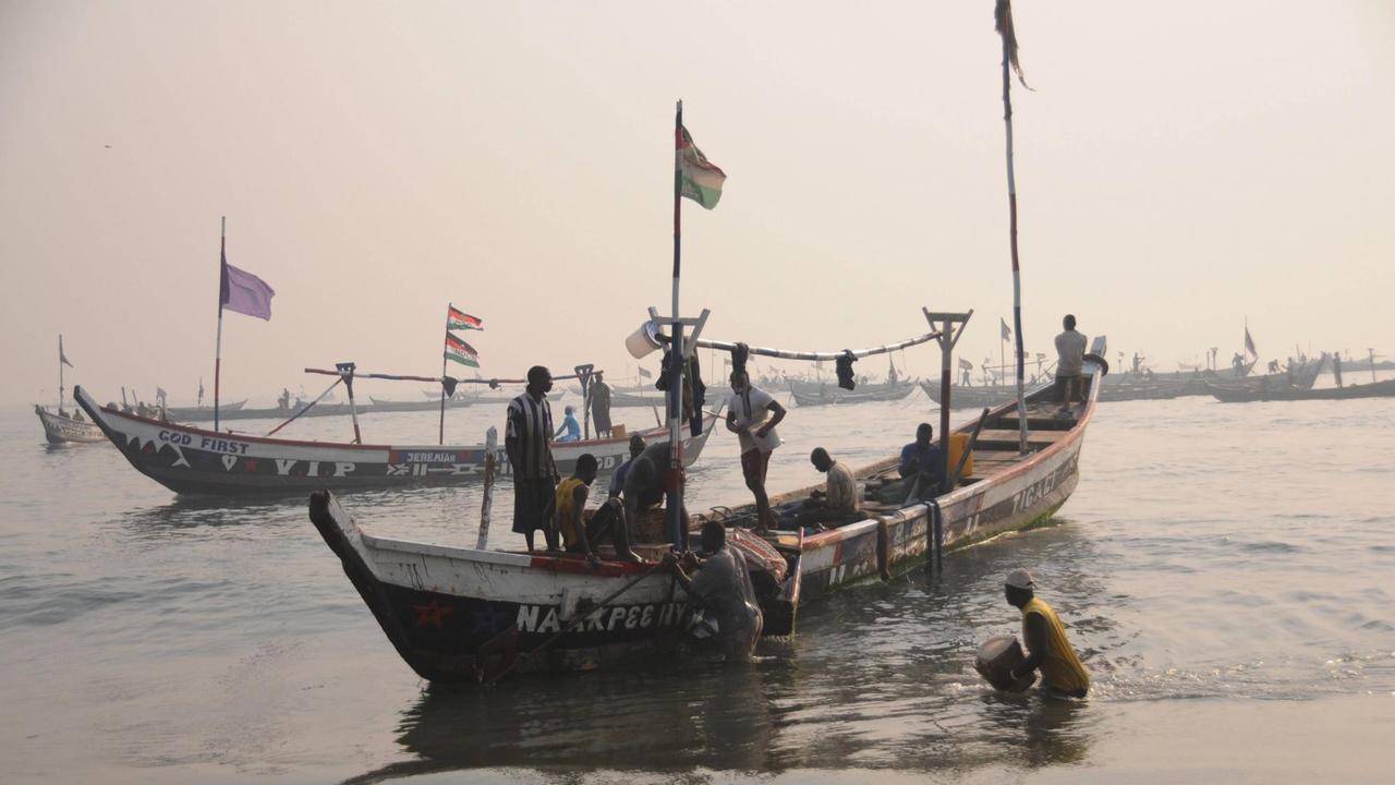 Fischer ziehen ein Boot an Land am Fischereihafen in Jamestown in Accra, der Hauptstadt von Ghana.