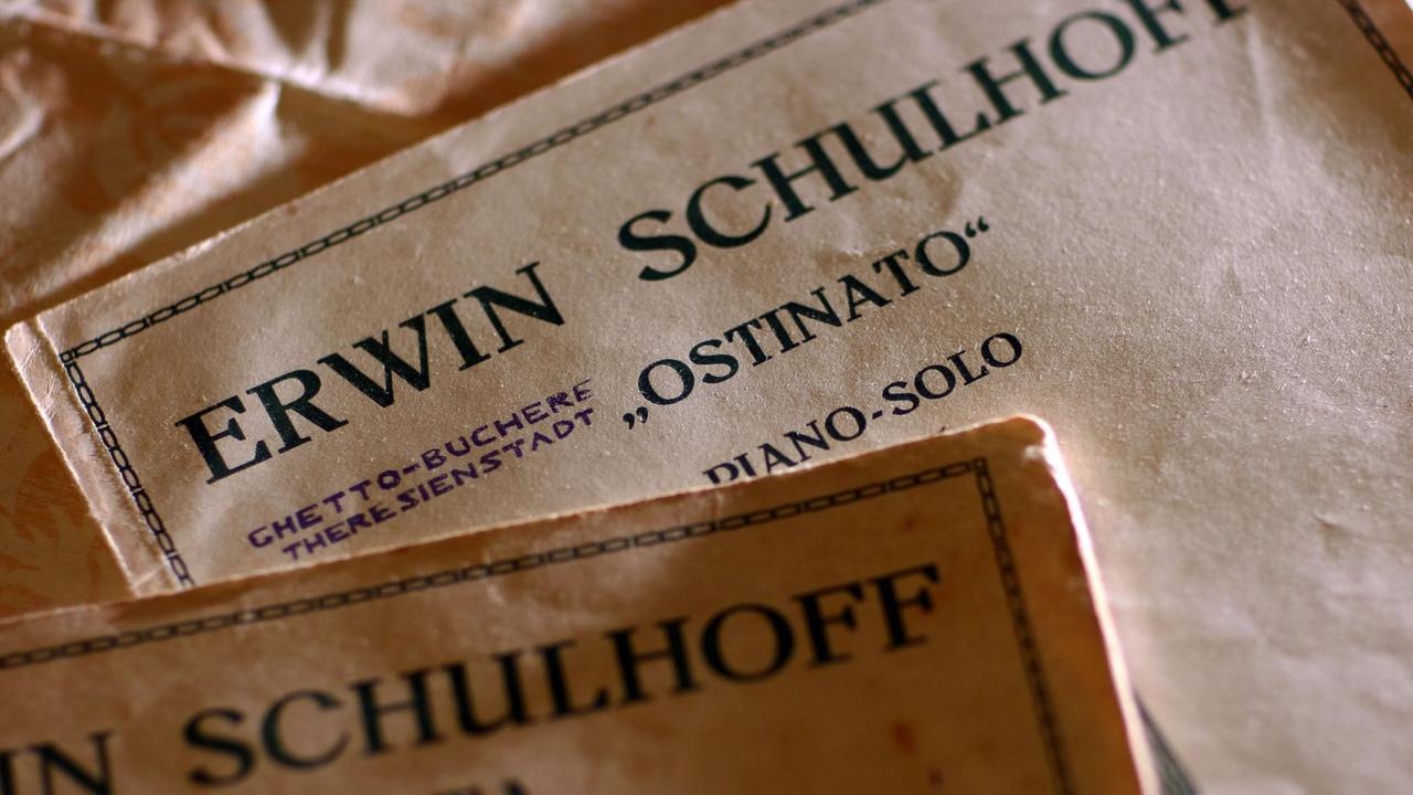 Verschiedene Notenbände auf einem Tisch, die den Komponistennamen Erwin Schulhoff tragen. Verschiedene Notenbände auf einem Tisch, die den Komponistennamen Erwin Schulhoff tragen.