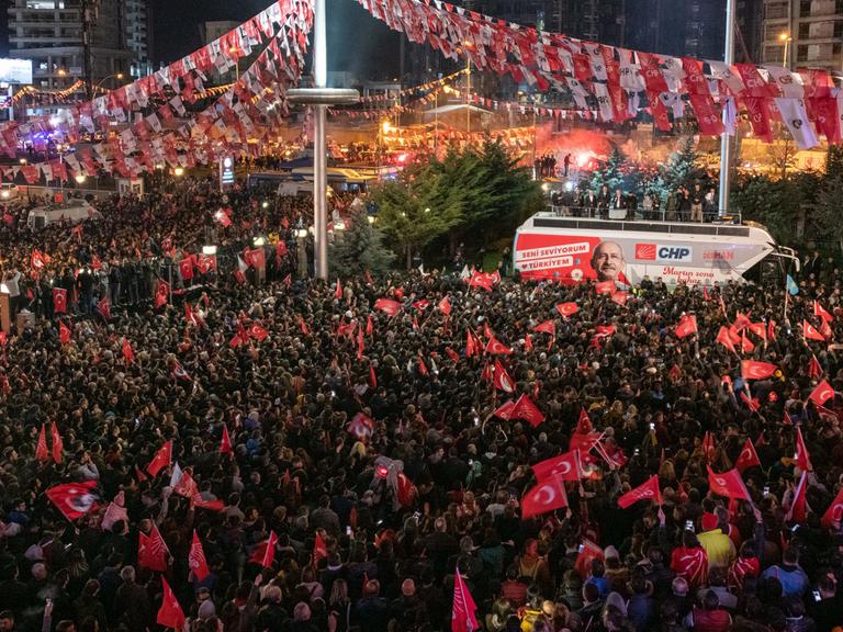 Eine Menschenmenge hat sich rund um einen Bus mit dem Bild des Kandidaten der türkischen Oppositionspartei CHP in Ankara versammelt und schwenkt türkische Flaggen.