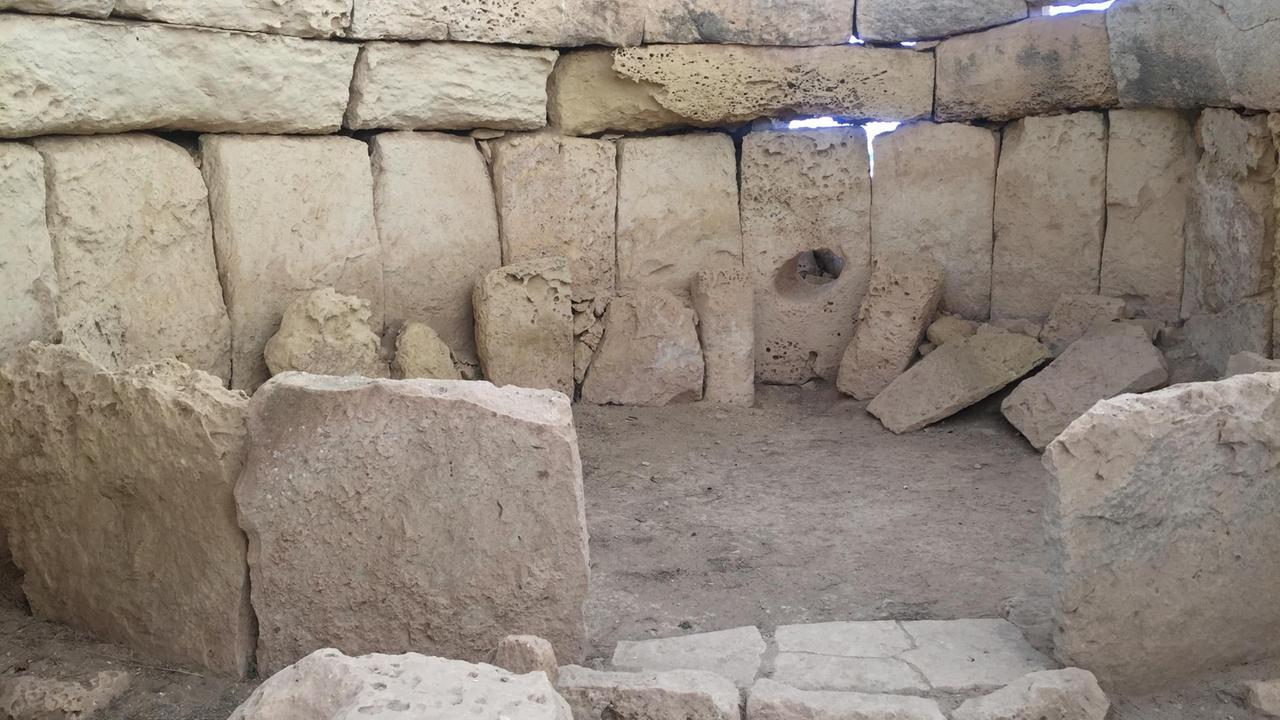 Der Megalithtempel Ħaġar Qim von innen zeigt große Felsen zu einem Halbkreis zusammengeschoben. Der Megalithtempel Ħaġar Qim von innen zeigt große Felsen zu einem Halbkreis zusammengeschoben.