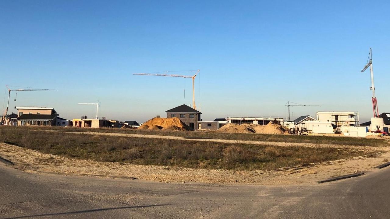 Eine Baustelle, auf der Neubauten und Kräne stehen. Der Himmel ist blau. Eine Baustelle, auf der Neubauten und Kräne stehen. Der Himmel ist blau.