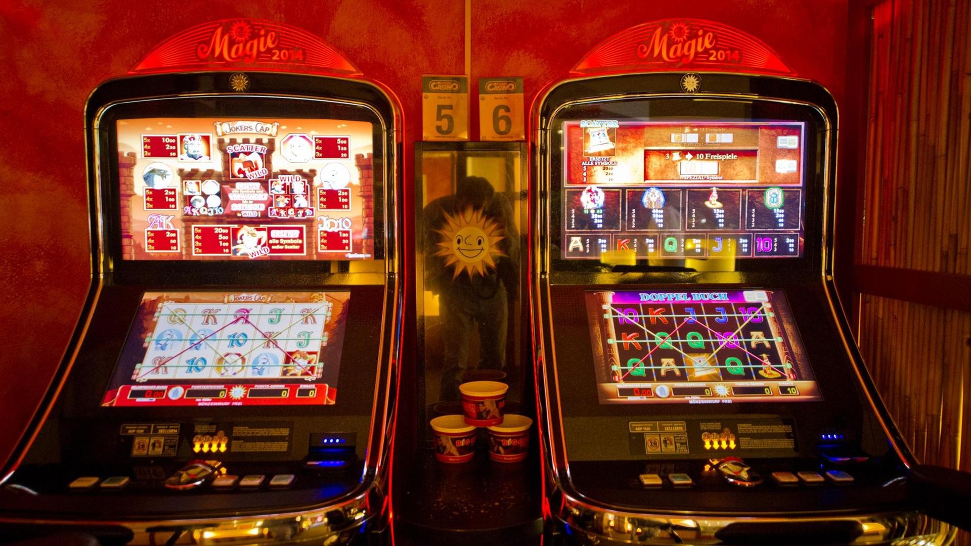 Zwei Spielautomaten stehen nebeneinander in einer Spiehalle Zwei Spielautomaten stehen nebeneinander in einer Spiehalle