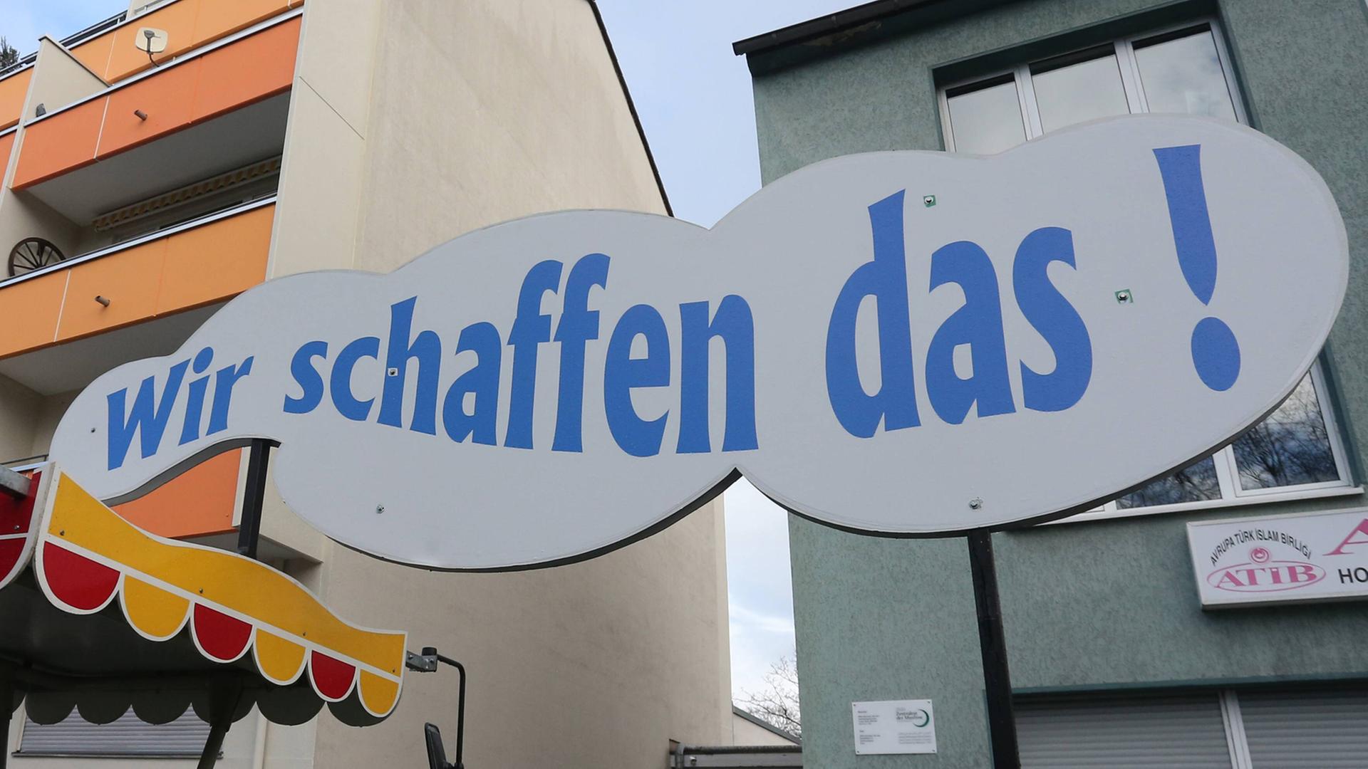 Das Zitat von Bundeskanzlerin Angela Merkel "Wir schaffen das!" steht auf einem wolkenförmigen Schild beim Rosenmontagszug in Köln im Februar 2016. Das Zitat von Bundeskanzlerin Angela Merkel "Wir schaffen das!" steht auf einem wolkenförmigen Schild beim Rosenmontagszug in Köln im Februar 2016.