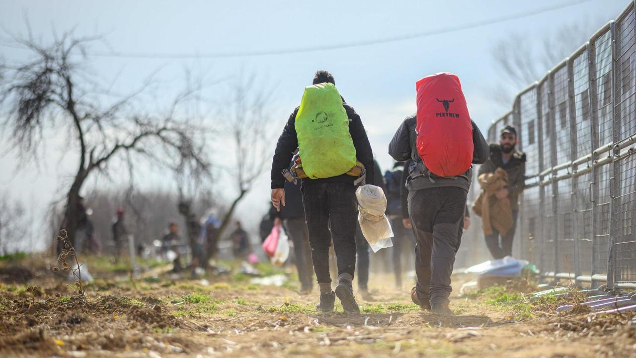 Flüchtlinge sind an einem türkischen Absperrzaun am Grenzübergang Pazarkule-Kastanies in Richtung Griechenland unterwegs. Flüchtlinge sind an einem türkischen Absperrzaun am Grenzübergang Pazarkule-Kastanies in Richtung Griechenland unterwegs.