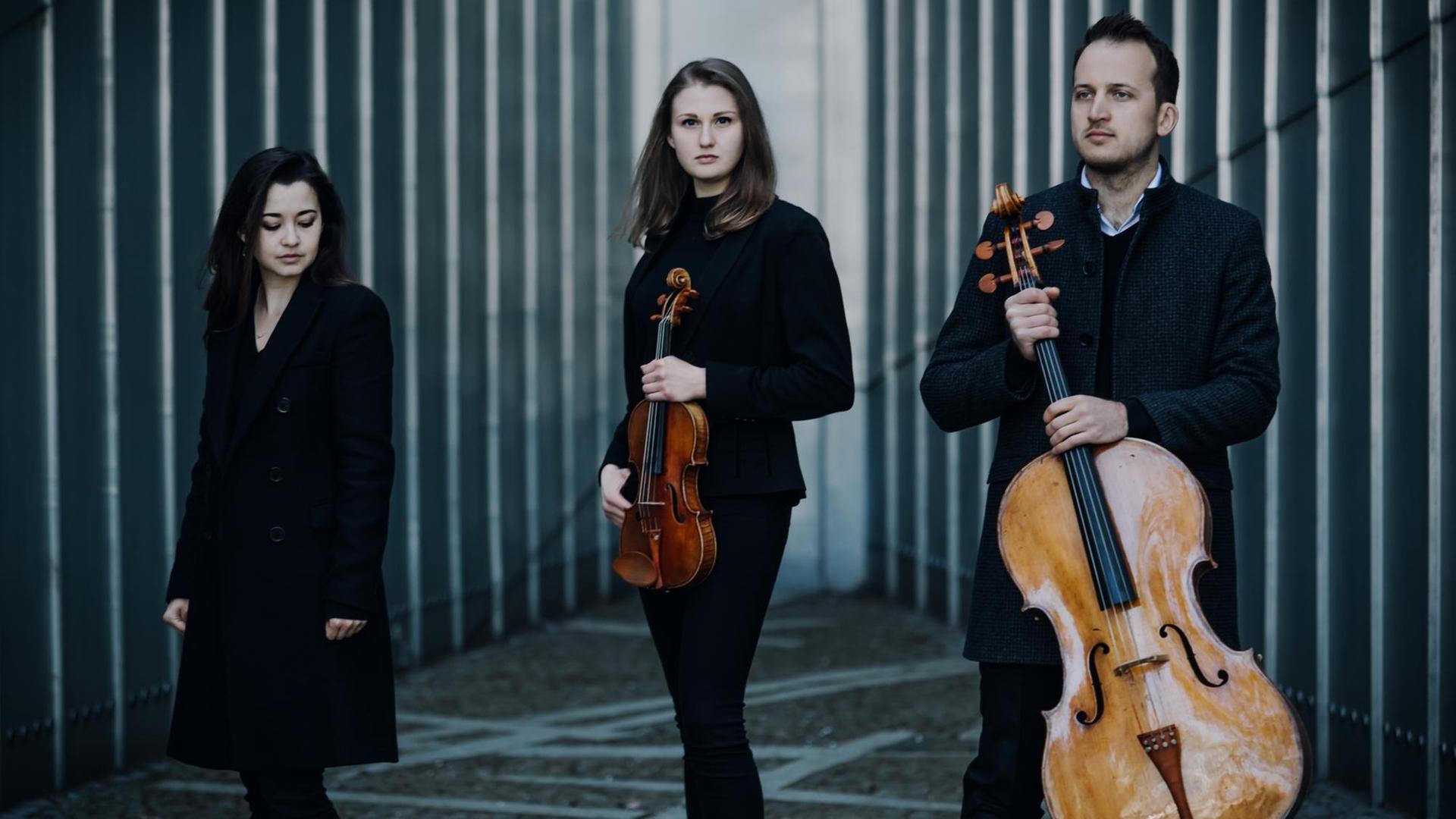 Das Trio Marvin steht auf einem modernen Platz und schaut in die Kamera. Das Trio Marvin steht auf einem modernen Platz und schaut in die Kamera.