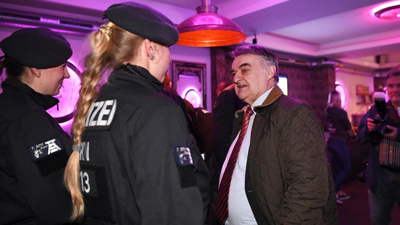 Herbert Reul (CDU), Innenminister von Nordrhein-Westfalen, spricht in einem Lokal mit Polizistinnen.