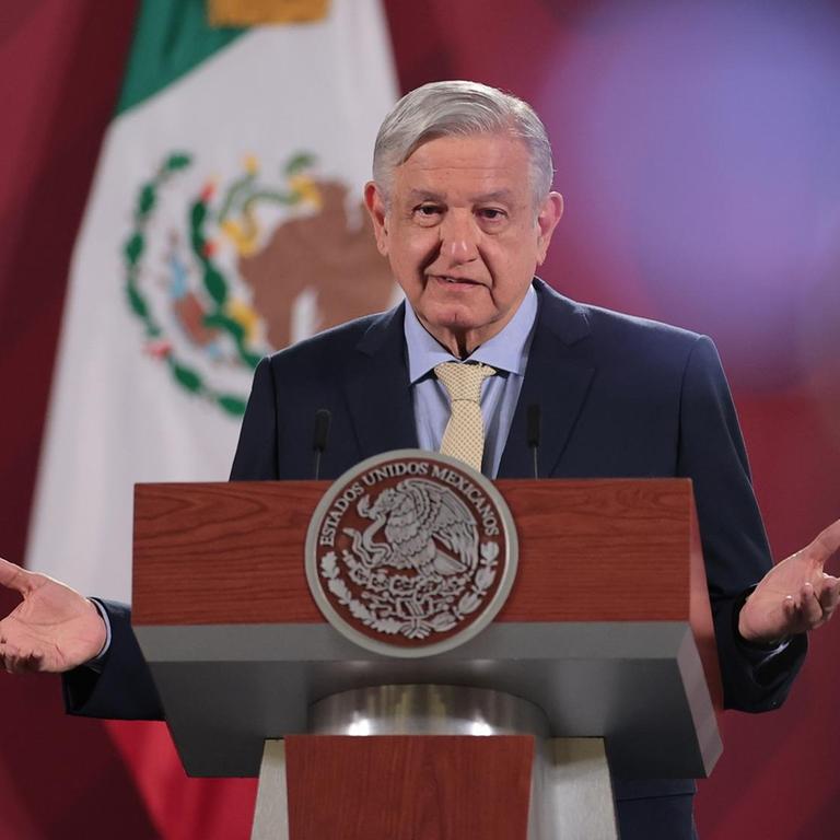 Der mexikanische Präsident Andres Manuel Lopez Obrador steht an einem Pult und spricht, im Hintergrund die mexikanische Flagge.