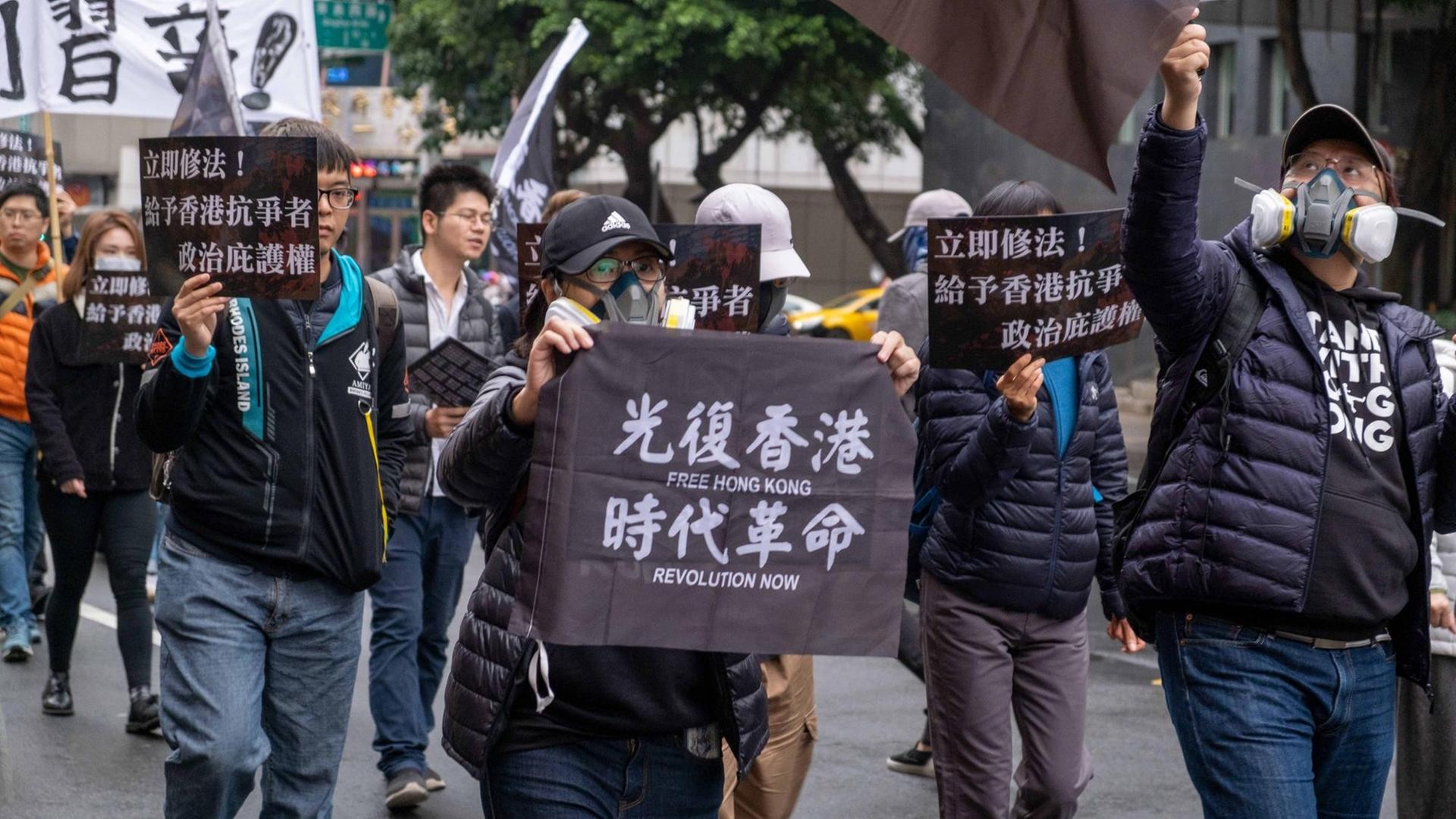 Taiwan: Eine Frau hält ein Plakat mit der Aufschrift "Frei Hongkong, Revolution jetzt während des Marsches". Mitglieder des Internationalen Sozialistischen Forward ISF marschierten in Taipeh und forderten Gesetzesänderungen, die es Taiwan ermöglichen würden, diese zu gewähren politisches Asyl für Hongkonger. Taiwan: Eine Frau hält ein Plakat mit der Aufschrift "Frei Hongkong, Revolution jetzt während des Marsches". Mitglieder des Internationalen Sozialistischen Forward ISF marschierten in Taipeh und forderten Gesetzesänderungen, die es Taiwan ermöglichen würden, diese zu gewähren politisches Asyl für Hongkonger.