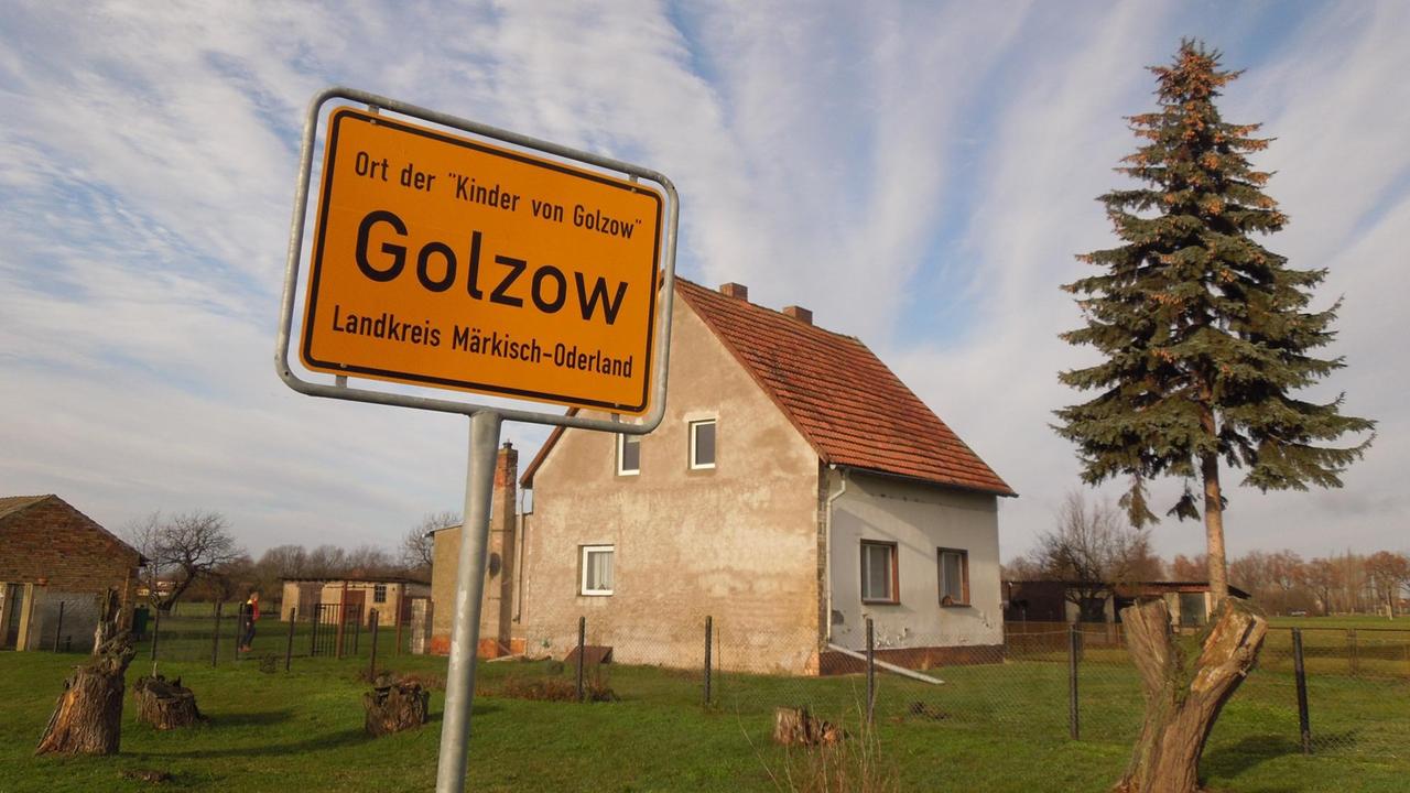 Ortsschild von Golzow, Haus im Hintergrund Ortsschild von Golzow, Haus im Hintergrund