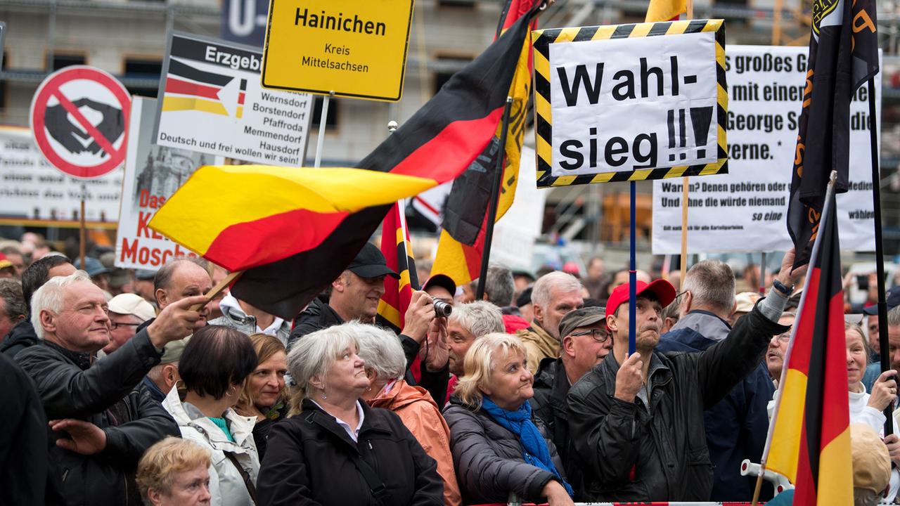 "Wahlsieg" steht auf einem der Transparente während der Kundgebung der islamfeindlichen Pegida-Bewegung am 25.09.2017 auf dem Neumarkt in Dresden (Sachsen). Betont einmütig haben Pegida und AfD am Montagabend in Dresden den Wahlerfolg der Rechtspopulisten bei der Bundestagswahl gefeiert. "Wahlsieg" steht auf einem der Transparente während der Kundgebung der islamfeindlichen Pegida-Bewegung am 25.09.2017 auf dem Neumarkt in Dresden (Sachsen). Betont einmütig haben Pegida und AfD am Montagabend in Dresden den Wahlerfolg der Rechtspopulisten bei der Bundestagswahl gefeiert.