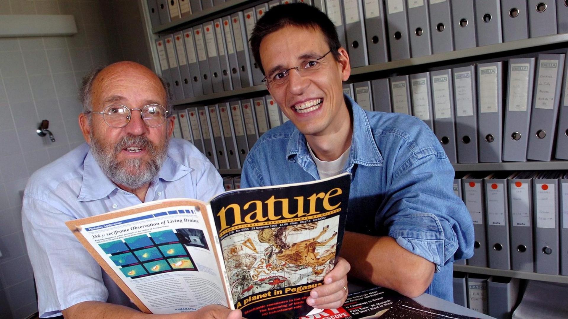 Die Astronomen Michel Mayor (R) and Didier Queloz (L) posieren mit der Ausgabe der "Nature", wo sie ihre Entdeckung veröffentlicht haben Die Astronomen Michel Mayor (R) and Didier Queloz (L) posieren mit der Ausgabe der "Nature", wo sie ihre Entdeckung veröffentlicht haben
