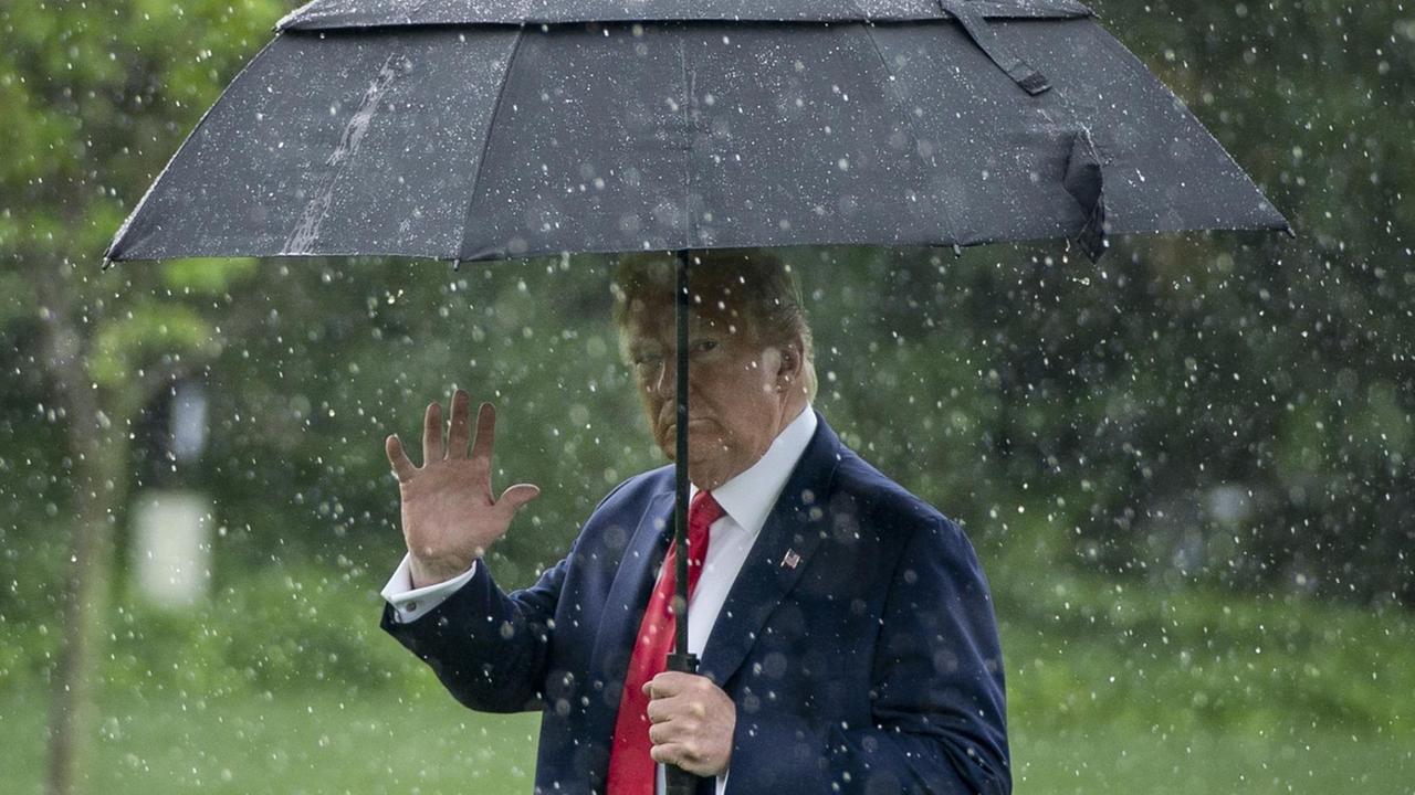 Donald Trump im Regen auf dem Weg zur "Marine One" vor dem weissen Haus in Washington, auf dem Weg nach Dallas, Texas. 2020. Donald Trump im Regen auf dem Weg zur "Marine One" vor dem weissen Haus in Washington, auf dem Weg nach Dallas, Texas. 2020.