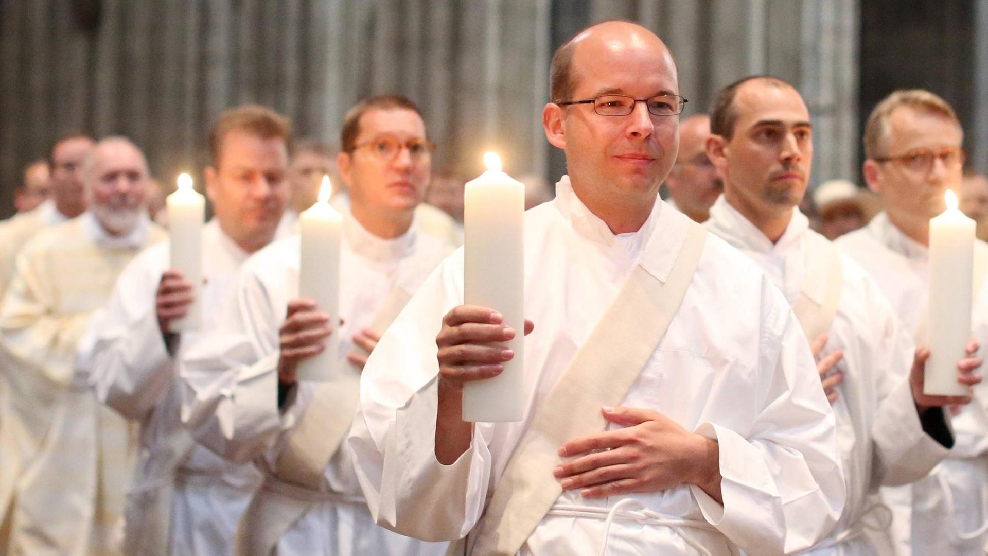 Priesteramtskandidaten ziehen zur Priesterweihe in den Dom von Köln ein. draw to Ordination to the priesthood in the Dom from Cologne a