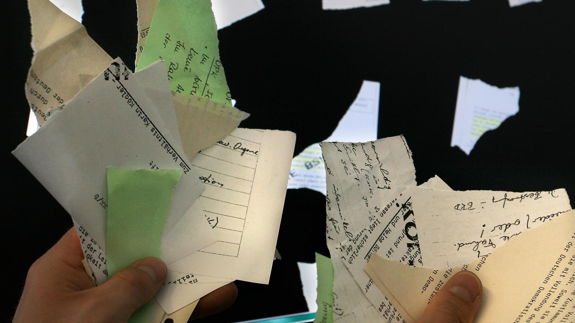 Zerrissene Stasi-Unterlagen hält ein Mitarbeiter des Fraunhofer Instituts in Berlin im Jahr 2007 vor bereits gescannte und an die Wand projezierte Stücke. Zerrissene Stasi-Unterlagen hält ein Mitarbeiter des Fraunhofer Instituts in Berlin im Jahr 2007 vor bereits gescannte und an die Wand projezierte Stücke.